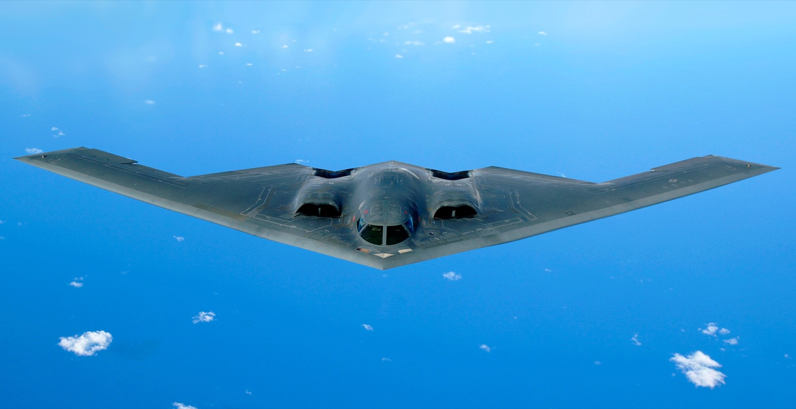 A B-2 Spirit stealth bomber in flight over open ocean
